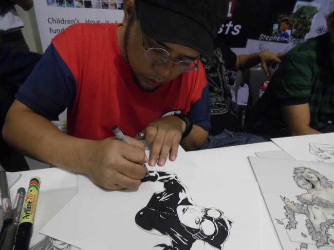 A comic artist drawing Catwoman on the spot at ToyCon 2014